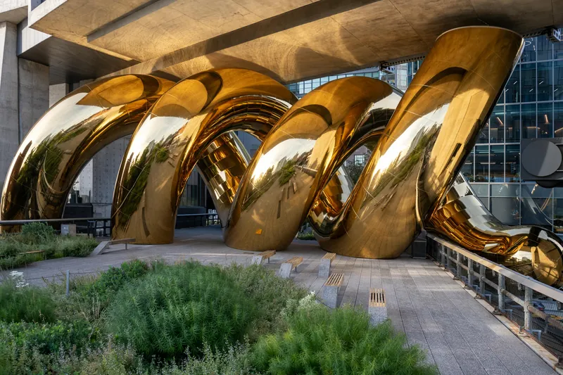 Installation auruBOROS de Bulgari Serpenti sur la High Line à New York : spirales dorées sous un bâtiment