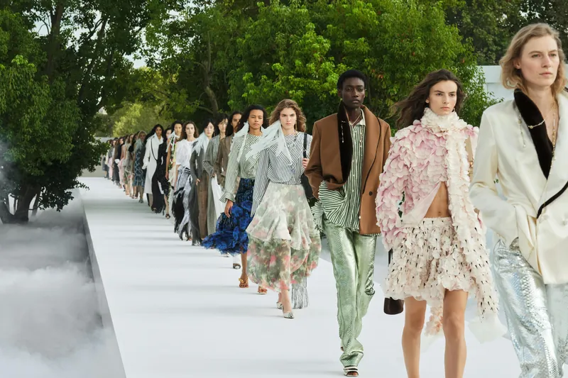 Final du défilé femme Dior Été 2027 : mannequins sur un podium blanc entre arbres et brume